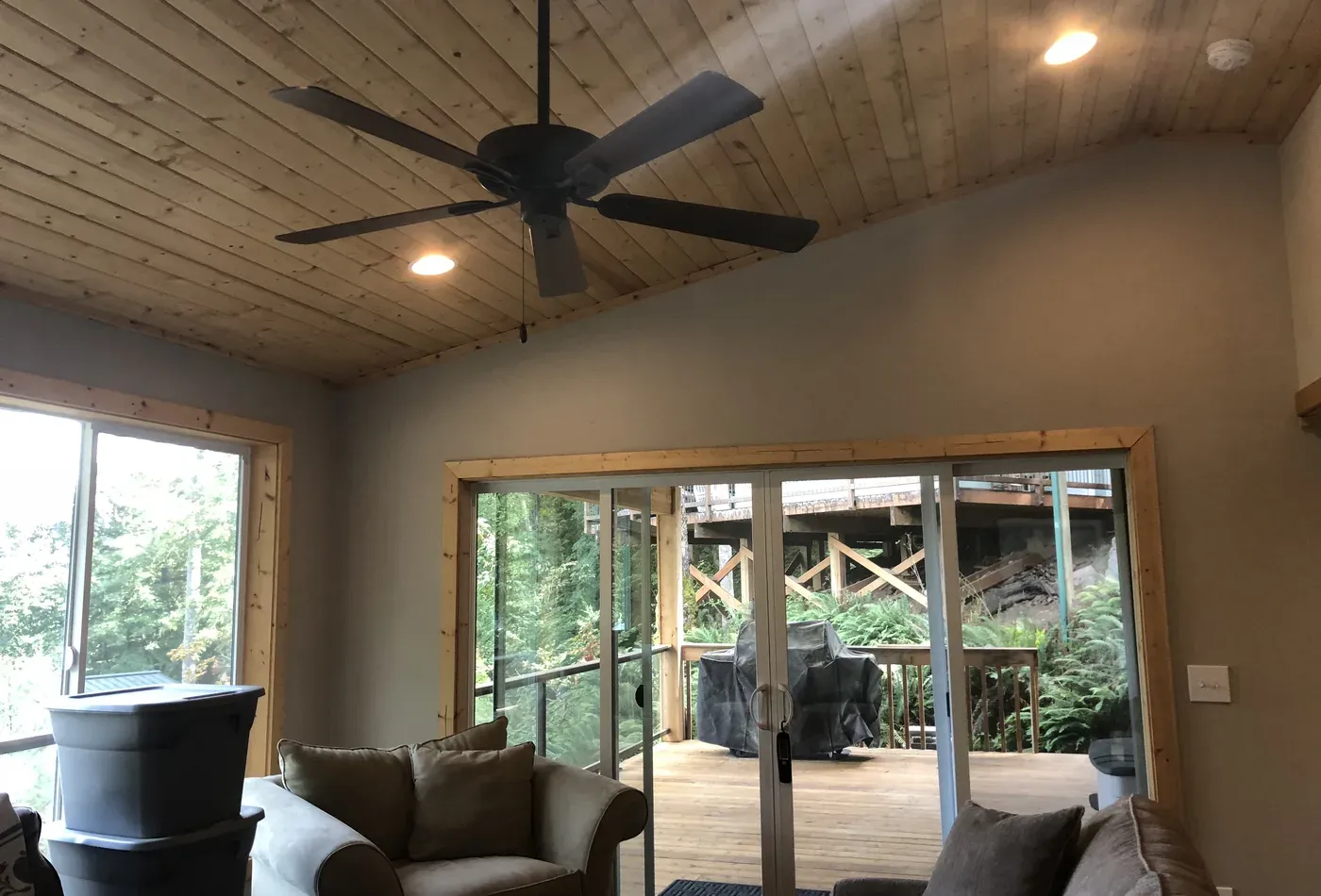 Tongue and groove wood ceiling with windows overlooking forest